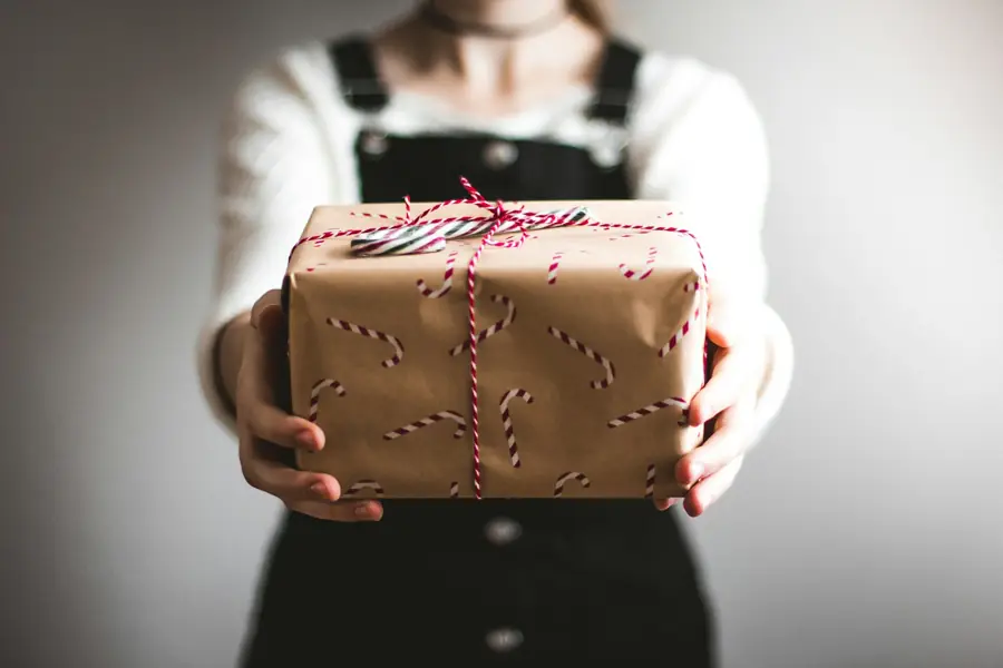Person holding a gift box wrapped in kraft paper